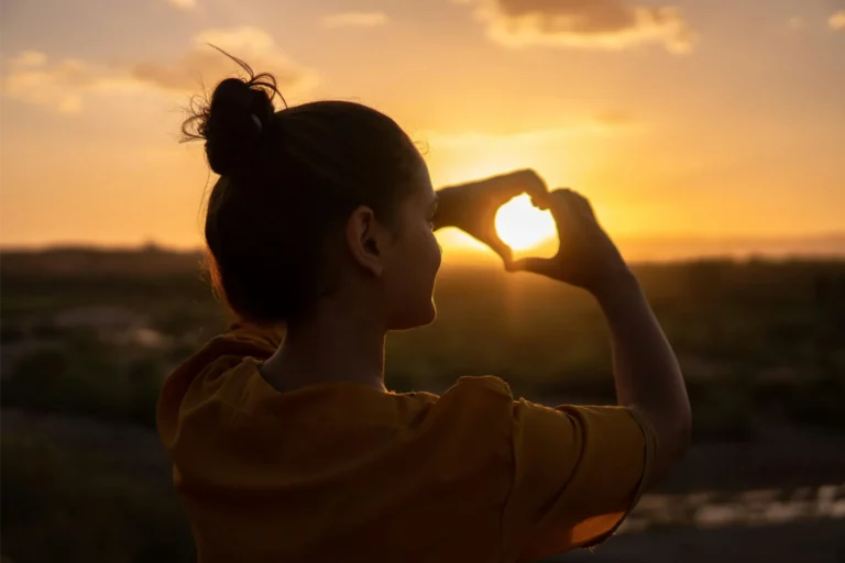 Woman holding hands in heart shape